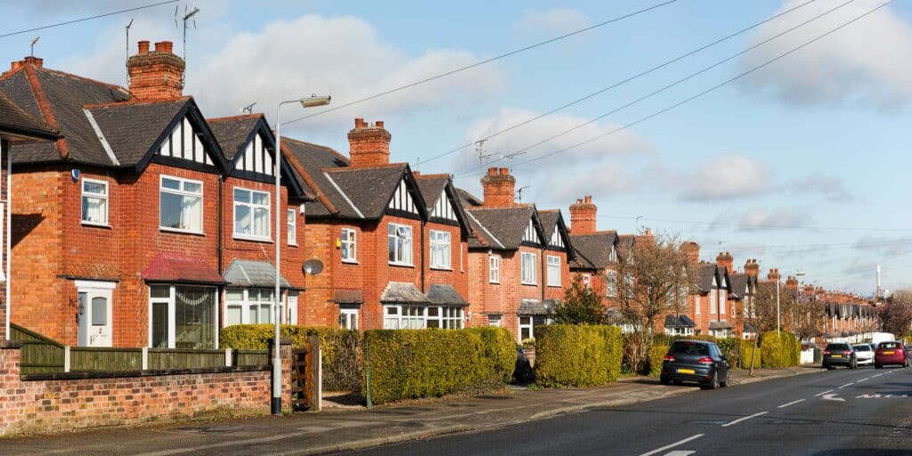 a typical UK street with red brick semi-detached homes