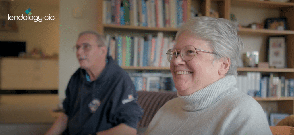Woman smiling whilst sat on her sofa
