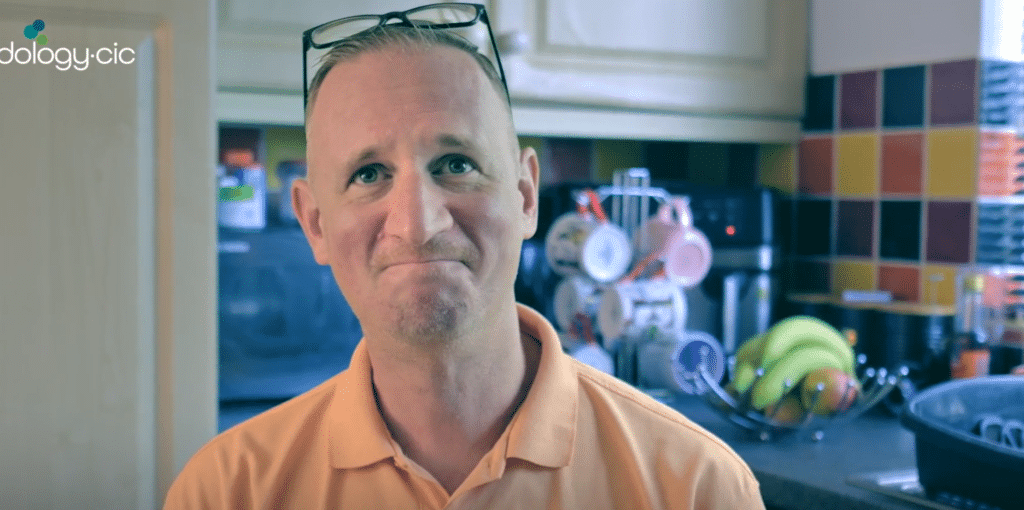 Man smiling at camera in his kitchen