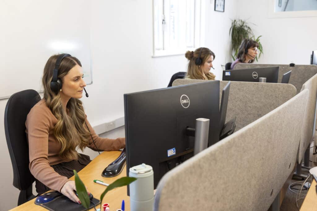 team members with headsets on, taking calls in the office from customers