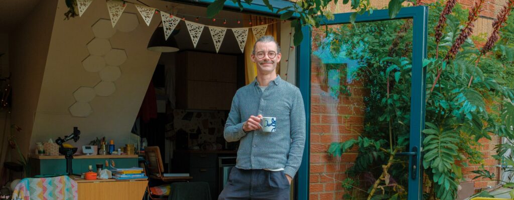 smiling man standing by open patio doors