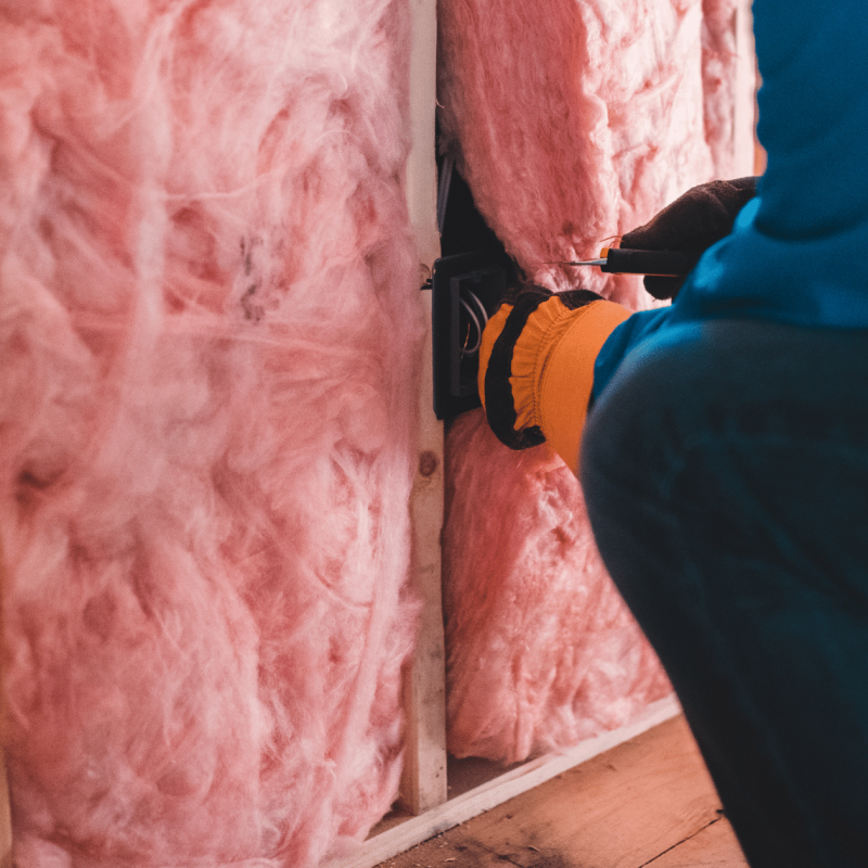 An installer installing insulation into a home