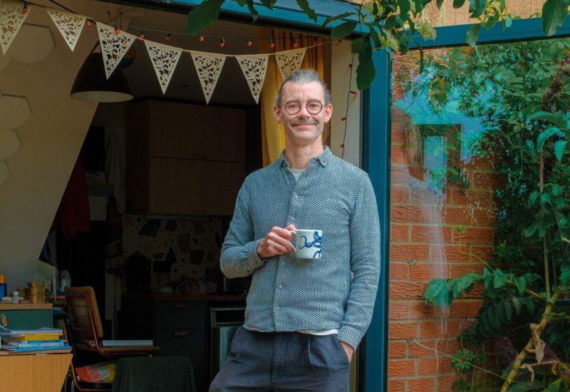 smiling man standing by open patio doors